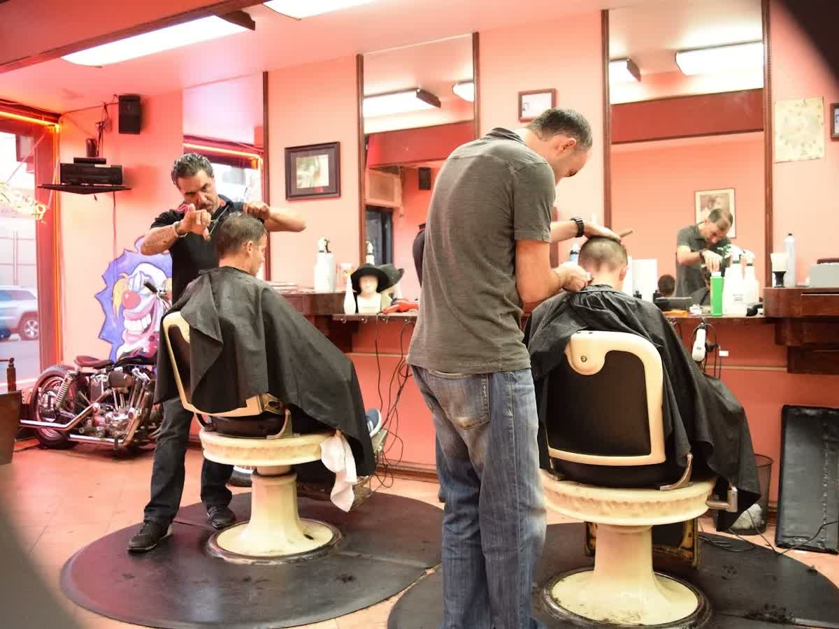Inside Manny's Barber & Stylist, barbers at work in the vintage chairs